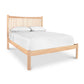 A Heartwood Shaker Low Footboard Bed by Vermont Furniture Designs with white sheets on it.