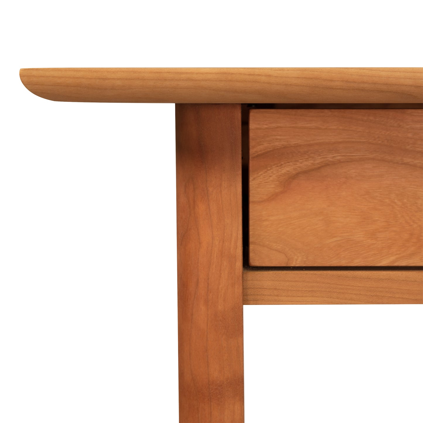 Corner of a Heartwood Shaker Writing Desk by Vermont Furniture Designs with a single drawer, against a white background.