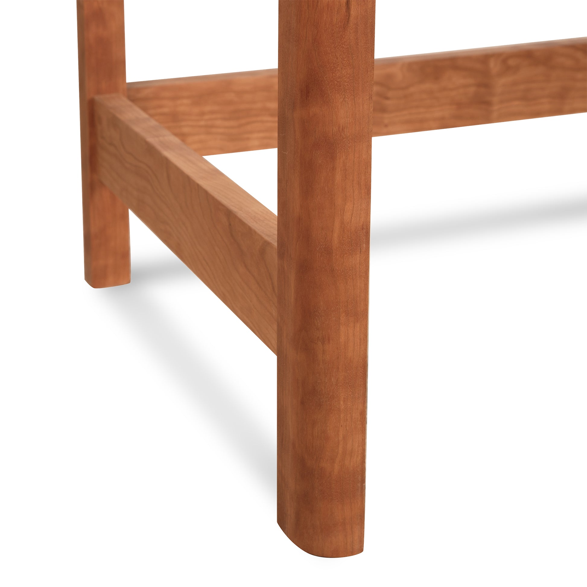 Close-up of a Vermont Furniture Designs Heartwood Shaker writing desk leg and crossbar, showcasing the wood grain and joinery details of sustainable cherry maple walnut.