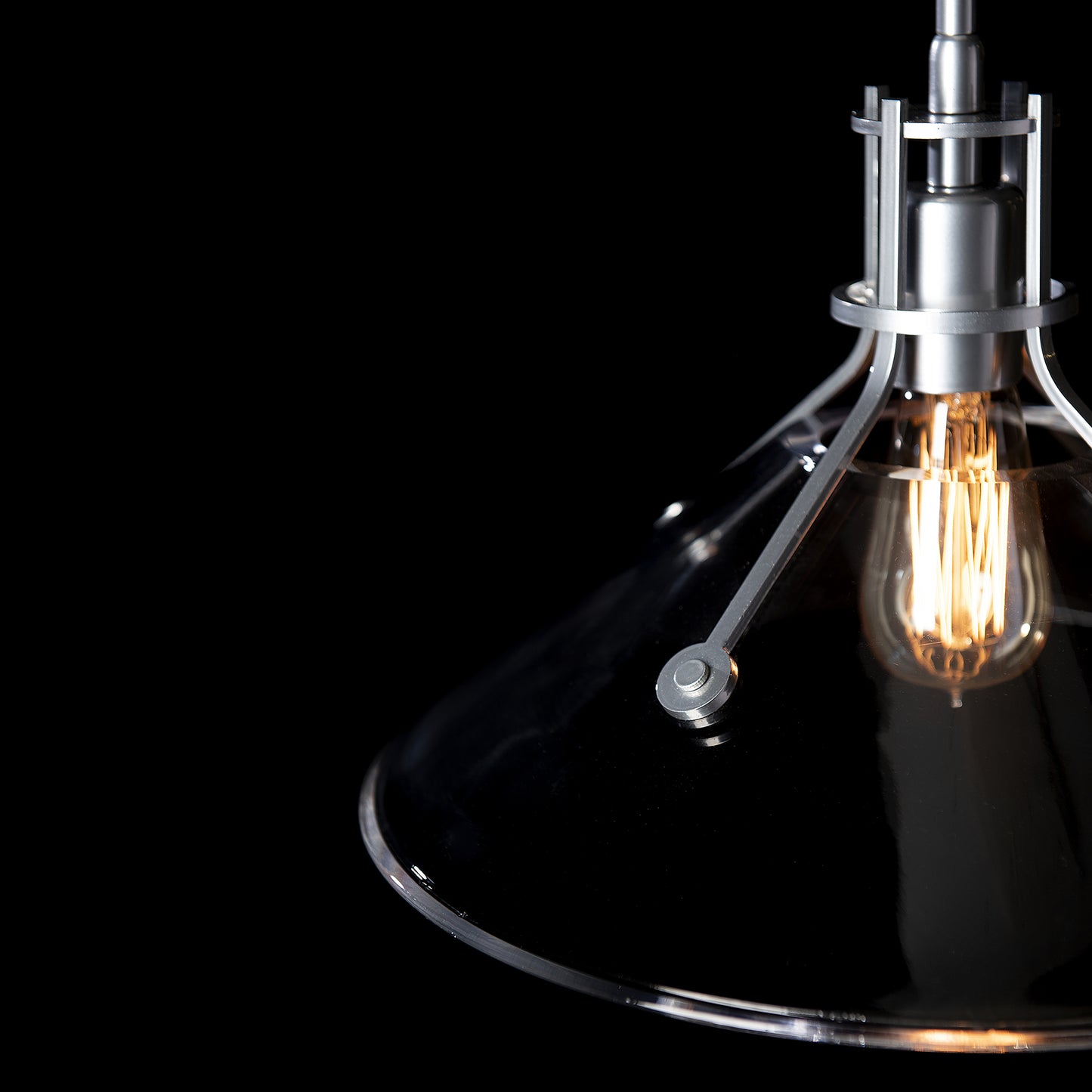 A modern industrial styled Henry Medium Glass Shade Pendant from Hubbardton Forge.