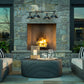 Round table with striped-cushion seating and Henry Outdoor 4-Light Pendant by Hubbardton Forge, highlighting elegant outdoor furniture.
