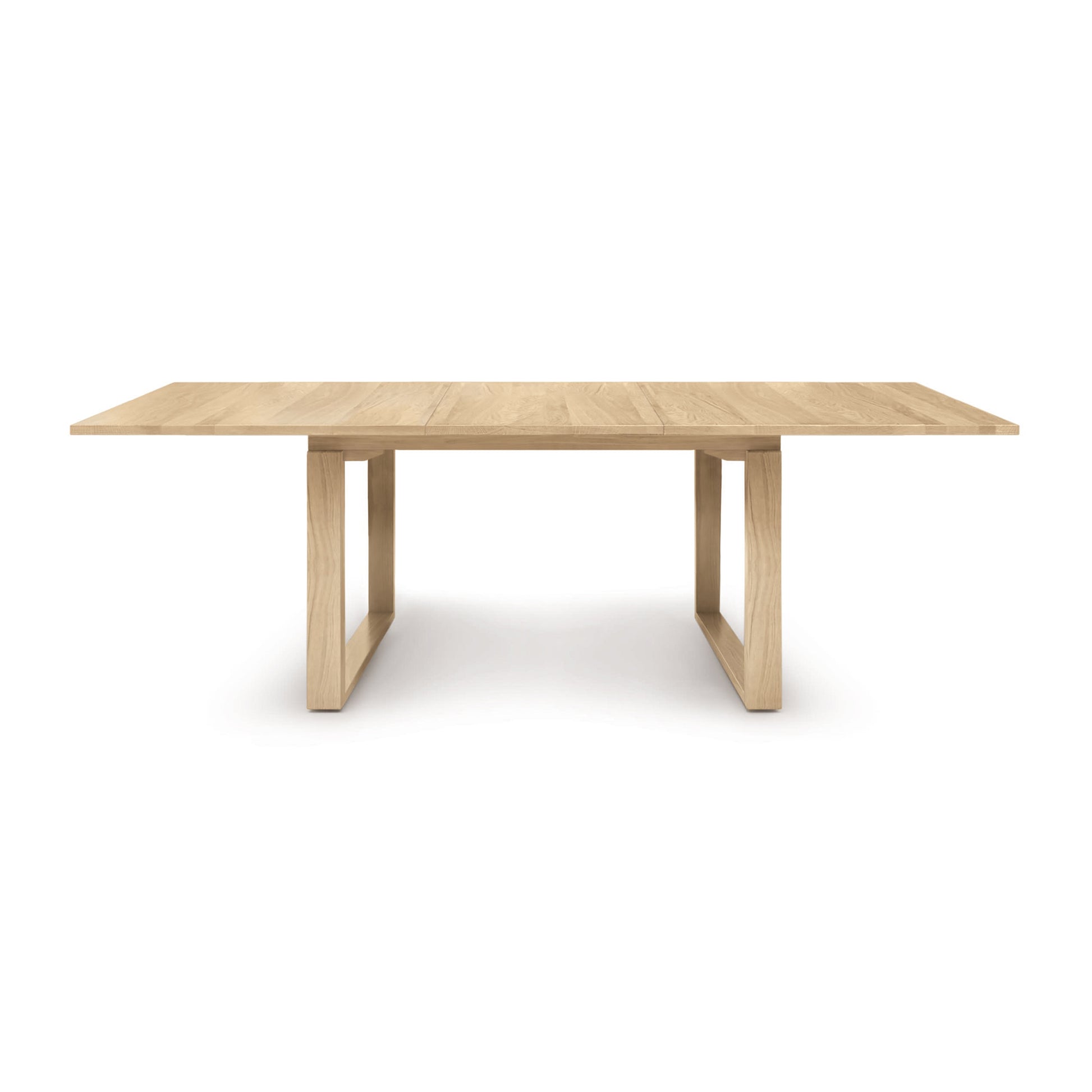An Iso Extension Dining Table with a solid oak wood base by Copeland Furniture.