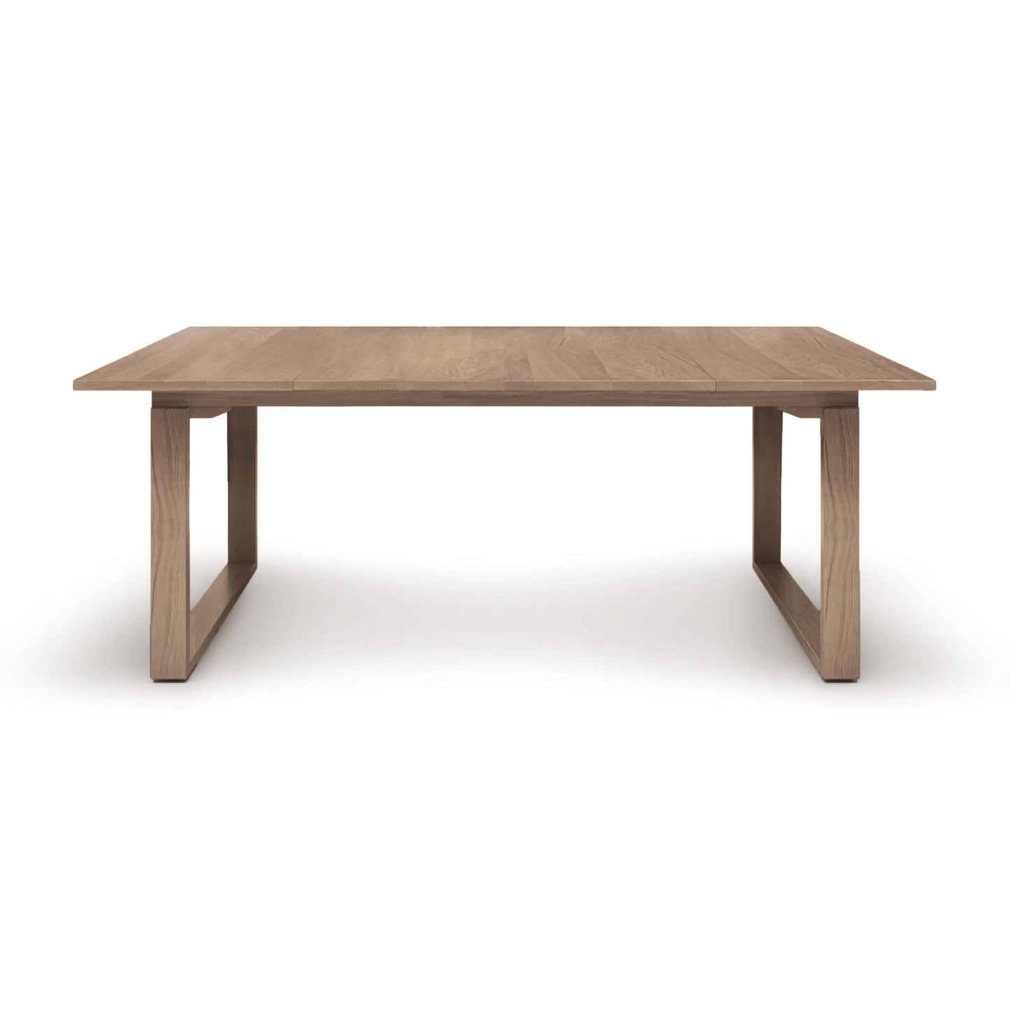 A rectangular Iso Extension Dining Table featuring solid oak wood, on a white background by Copeland Furniture.