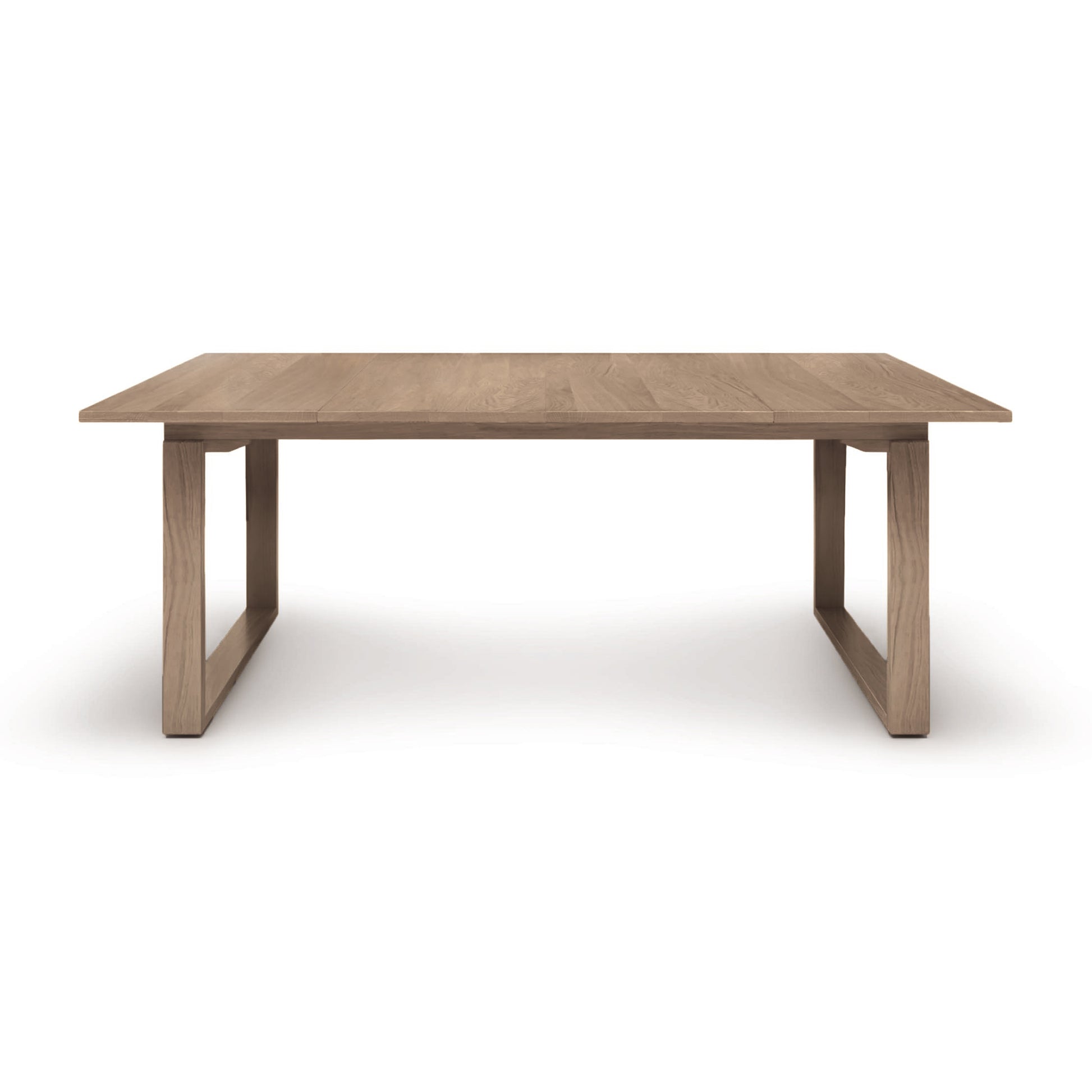 A rectangular Iso Extension Dining Table featuring solid oak wood, on a white background by Copeland Furniture.