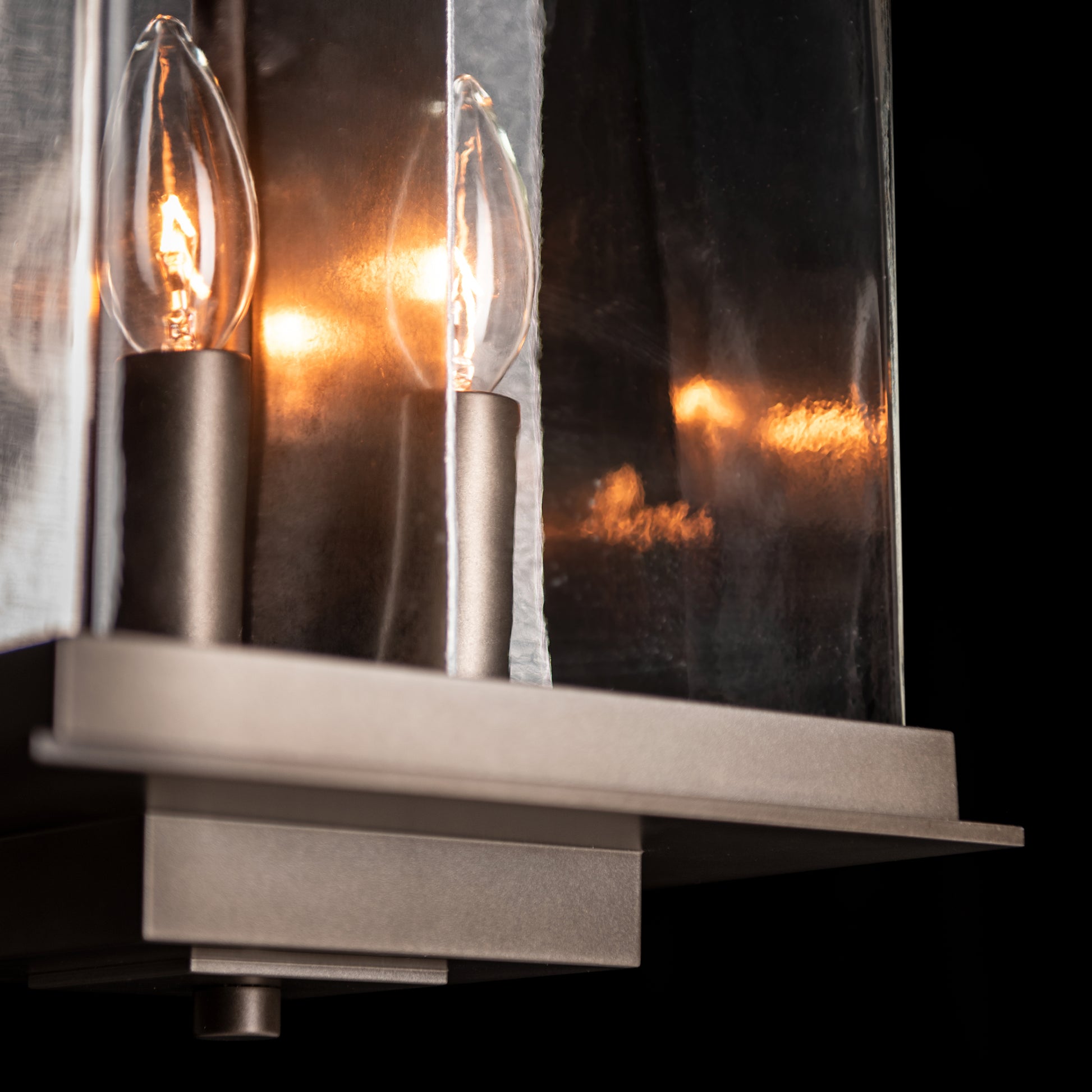 Hubbardton Forge Kingston Outdoor Large Lantern featuring two candle bulbs and clear glass panels, showcasing its elegant craftsmanship.