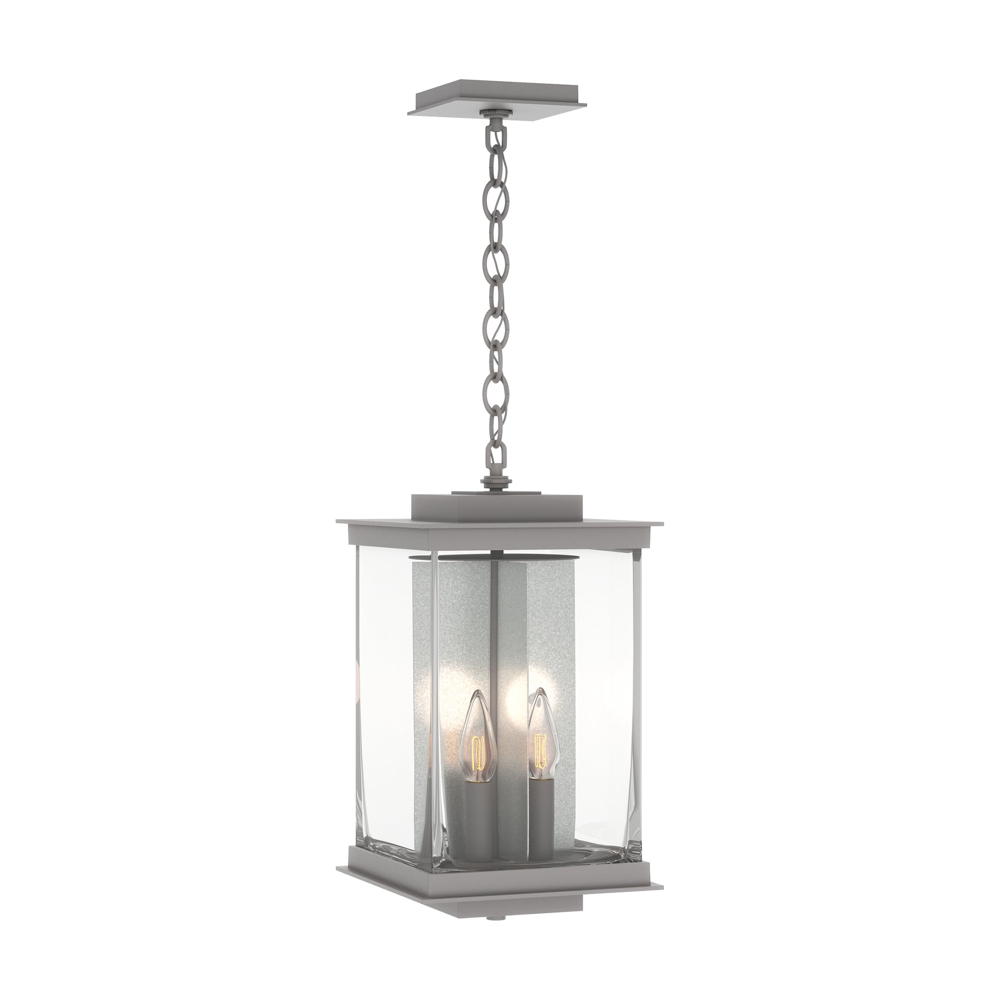 Kingston Outdoor Large Lantern by Hubbardton Forge with clear glass panels, metal frame, and two candle bulbs suspended inside the lantern.