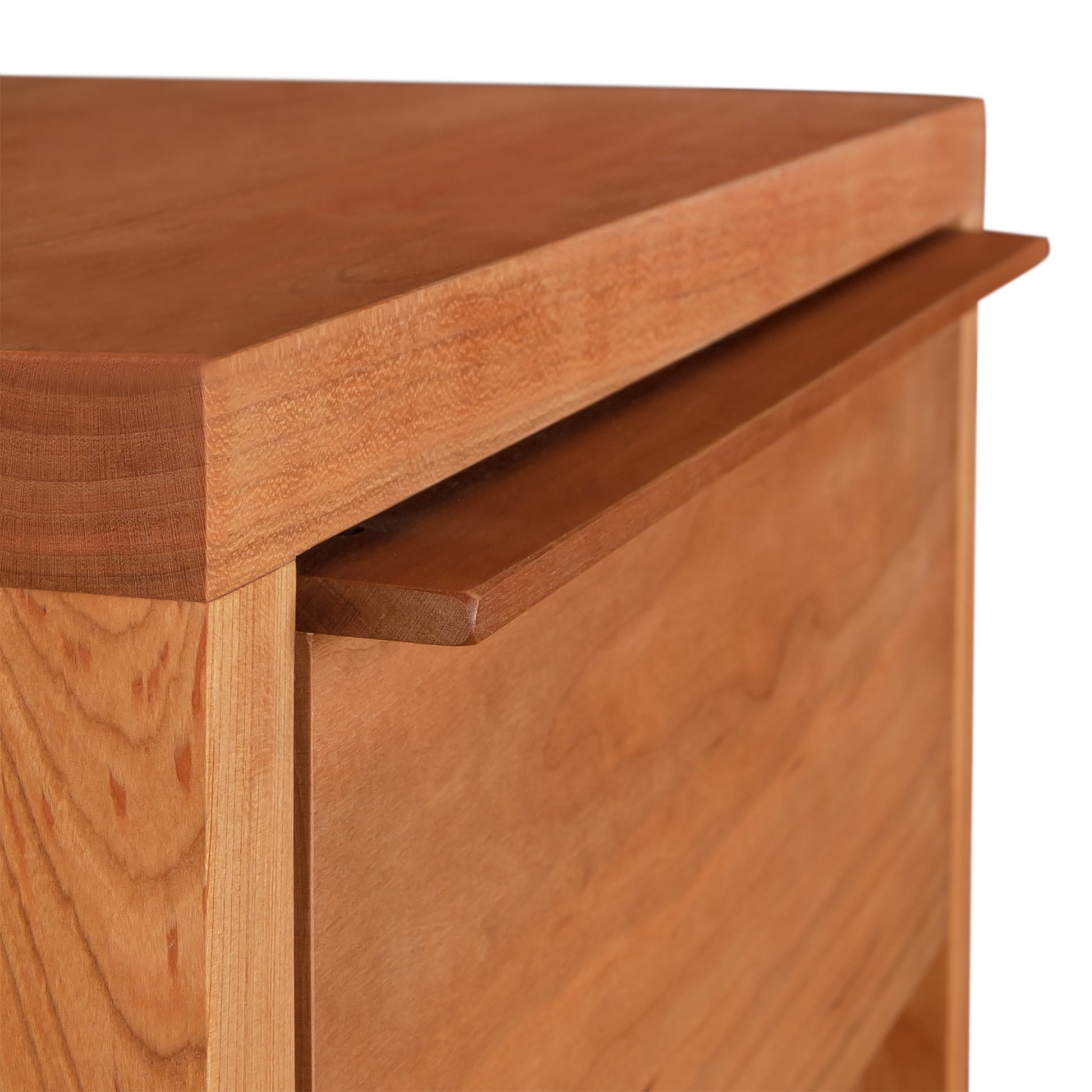 Close-up of a wooden drawer partially open, showcasing its handle and wood grain texture of the Vermont Furniture Designs Kipling 1-Drawer Enclosed Shelf Nightstand.