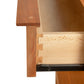 Close-up of the Vermont Furniture Designs Kipling 1-Drawer Enclosed Shelf Wide Nightstand, showcasing a wooden drawer with dovetail joints and a sleek metal sliding mechanism, crafted in cherry for a modern design.