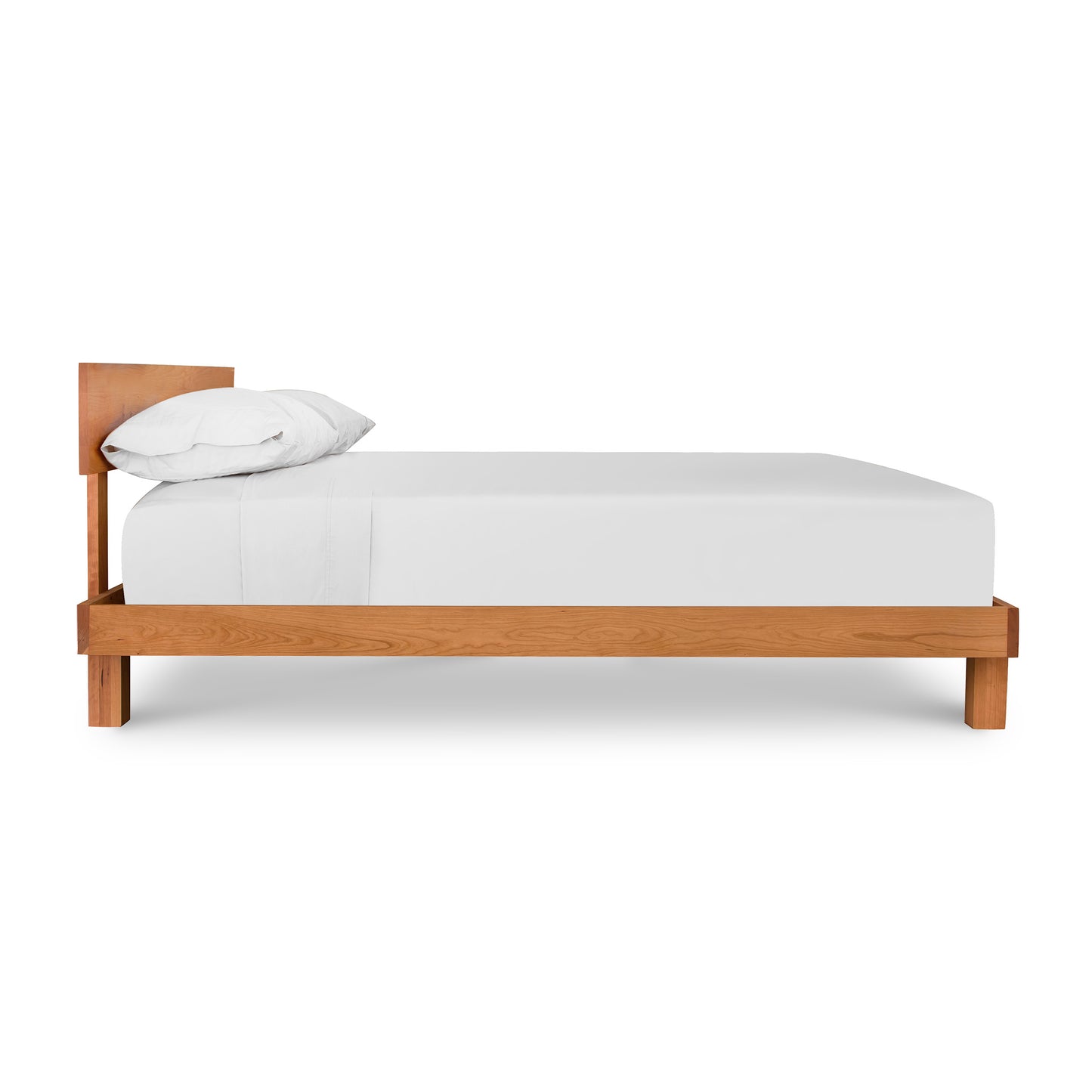 A single solid wood Vermont Furniture Designs Kipling Bed frame with a white mattress and a single white pillow, isolated on a white background.