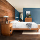 Modern bedroom with a solid wood accent wall, blue painted walls, and minimalist wooden furniture, featuring the Vermont Furniture Designs Kipling Platform Bed to customize your space.