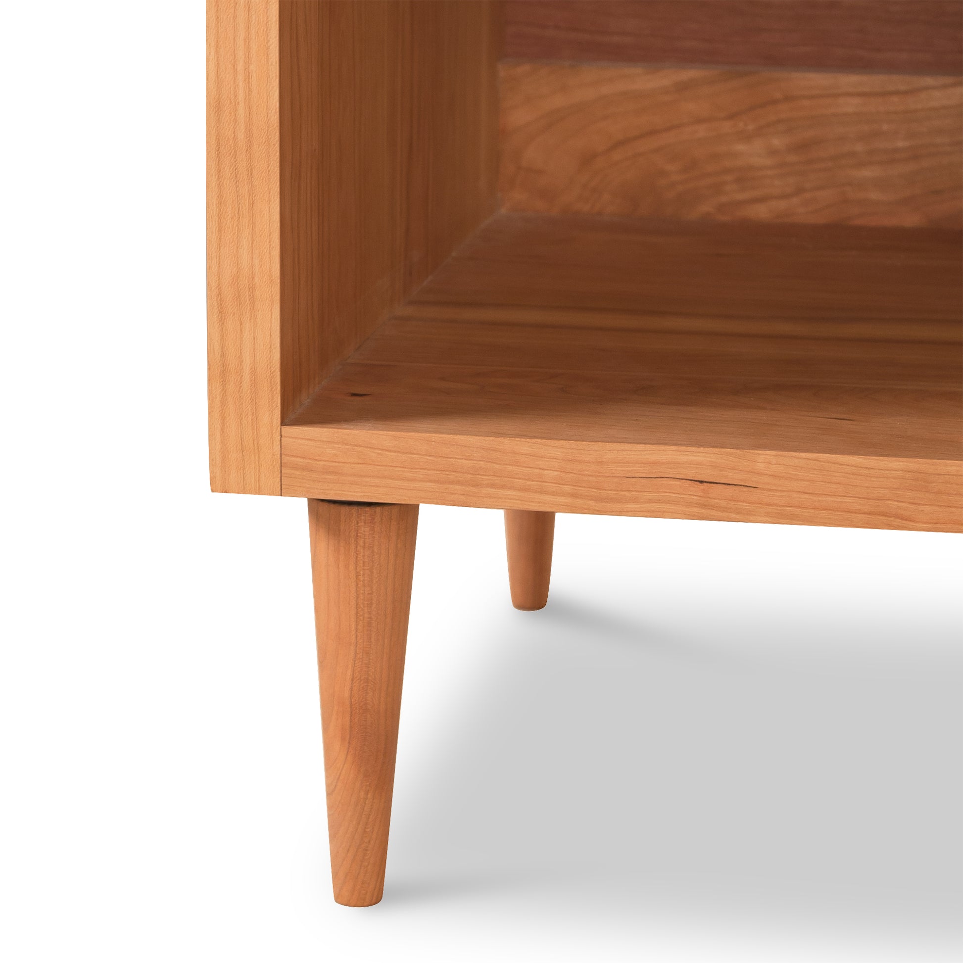 The Larssen 1-Drawer Enclosed Shelf Nightstand by Vermont Furniture Designs is a stunning wooden side table with two legs, featuring natural hardwoods and a mid-century modern design. It stands elegantly on a white background.