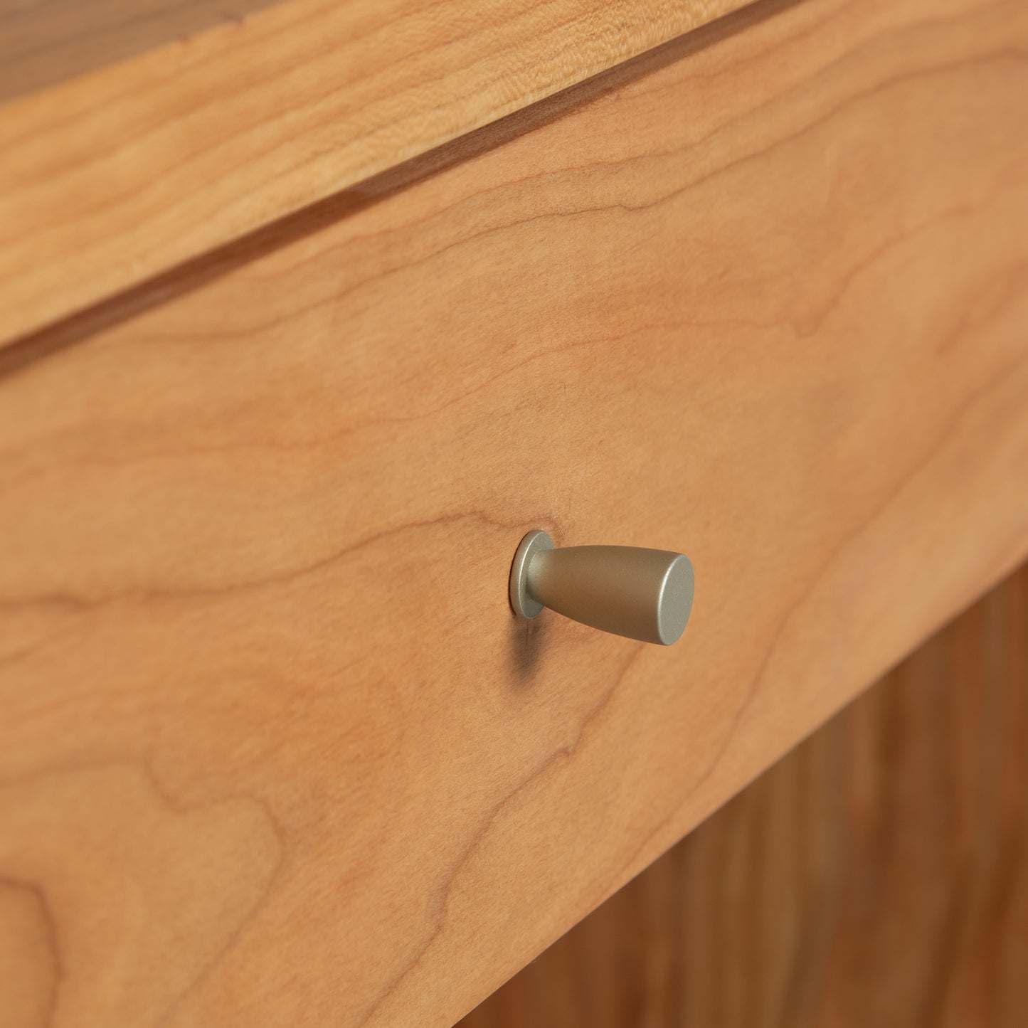 A close up of a wooden drawer with a metal knob from the Vermont Furniture Designs Larssen 1-Drawer Wide Nightstand.