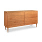 A Vermont Furniture Designs Larssen 8-Drawer Dresser with six drawers, crafted from natural solid hardwood, featuring a light brown finish and tapered legs, isolated on a white background.