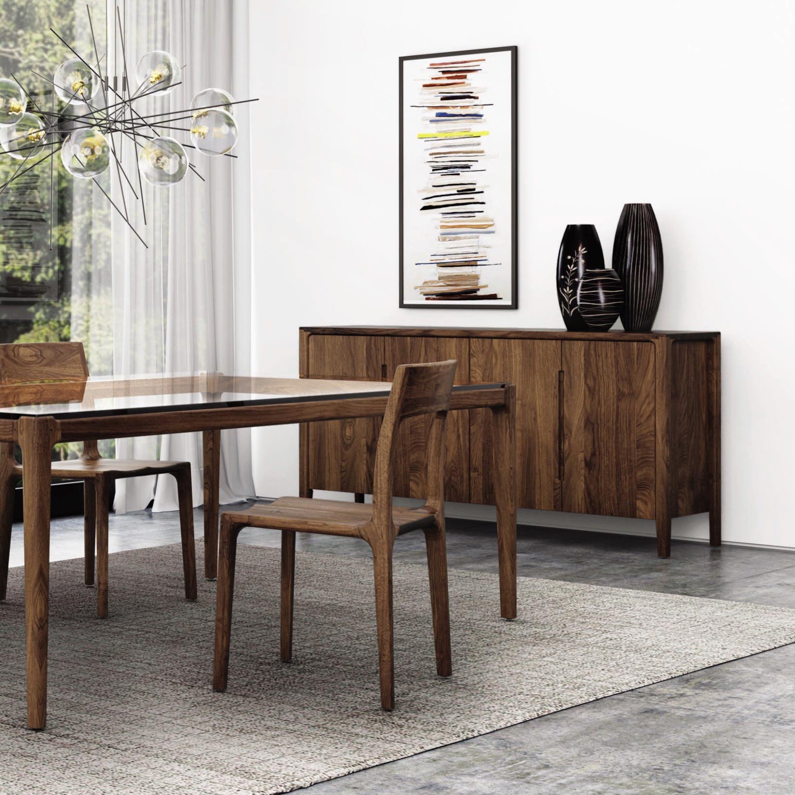 A modern dining room features a wooden table with matching chairs on a gray rug. Against the wall, Copeland Furniture's Lisse Buffet in walnut showcases two decorative vases. A glass pendant light hangs above the table, and a framed abstract artwork is displayed on the wall, completing the modern design.