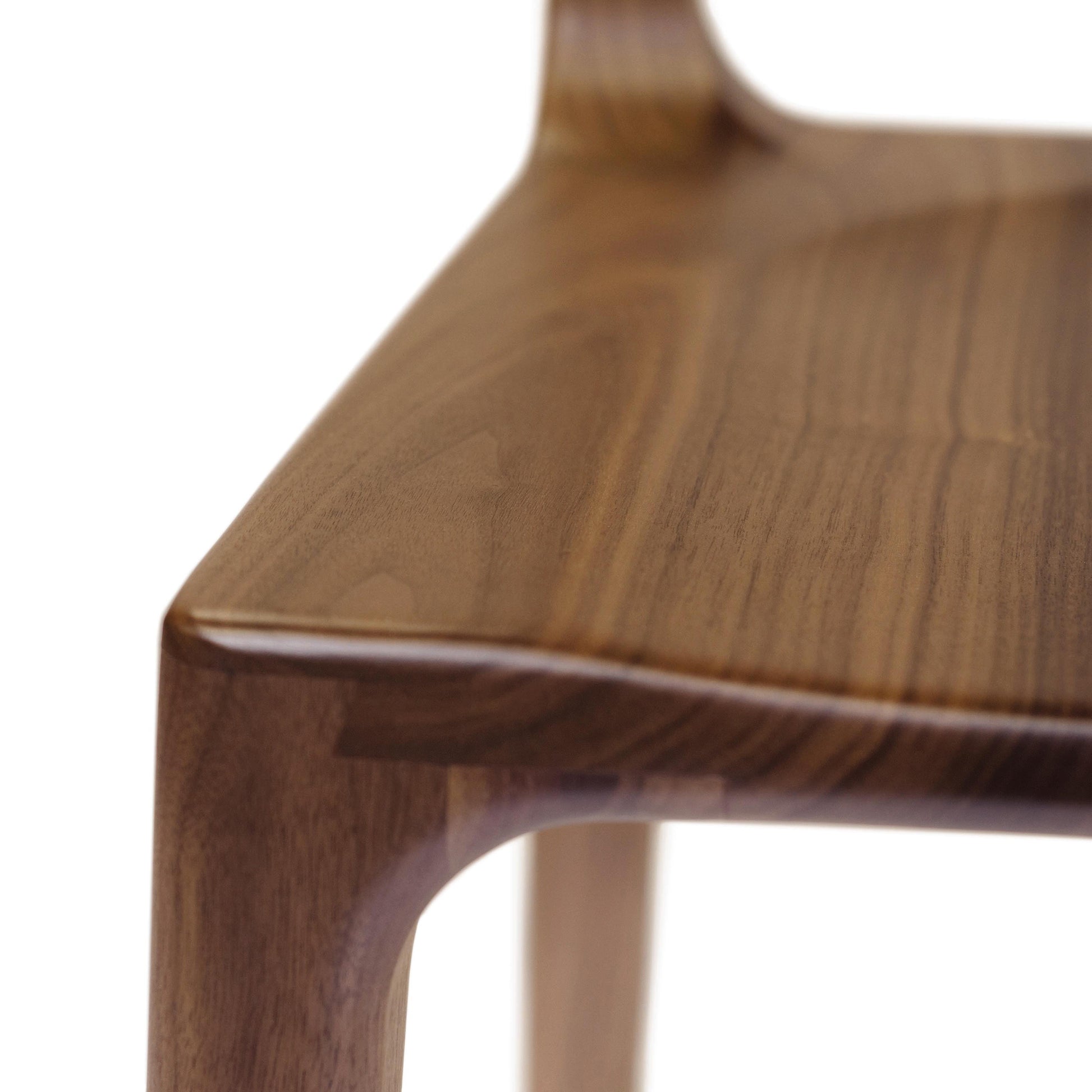A close up view of a walnut dining chair.