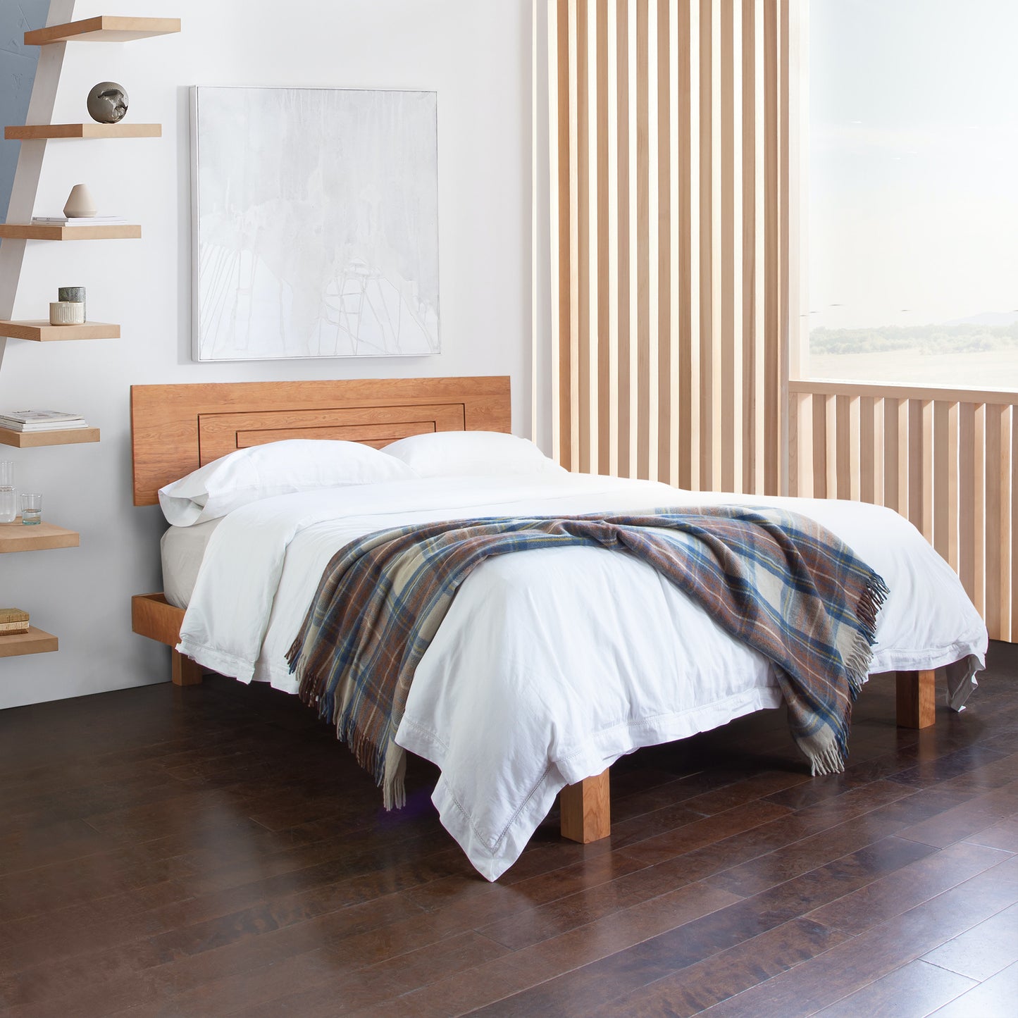 A bed in a bedroom with wooden floors.