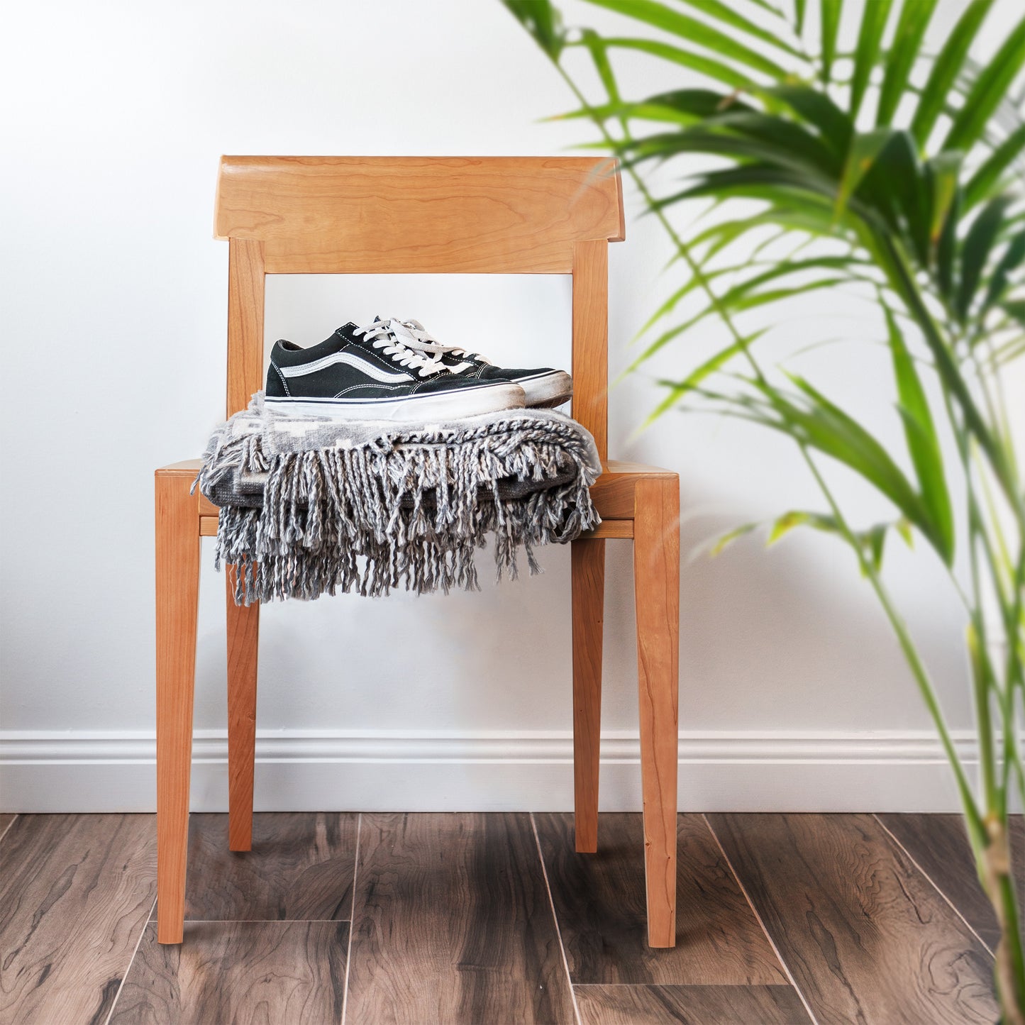 Vermont Woods Studios Ludlow Chair showcasing fine craftsmanship, accented with a gray fringed blanket draped over the seat.