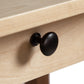 A black knob on a wooden table.