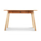 The Manchester Two-Tone Writing Desk in Cherry and Birch by Vermont Woods Studios features light-colored angled legs and a dark sustainable solid wood top. Perfect for a modern home office, this minimalist desk includes a single centered drawer with a round knob. Crafted from high-quality materials, this American-made furniture piece showcases simple elegance against a white background.