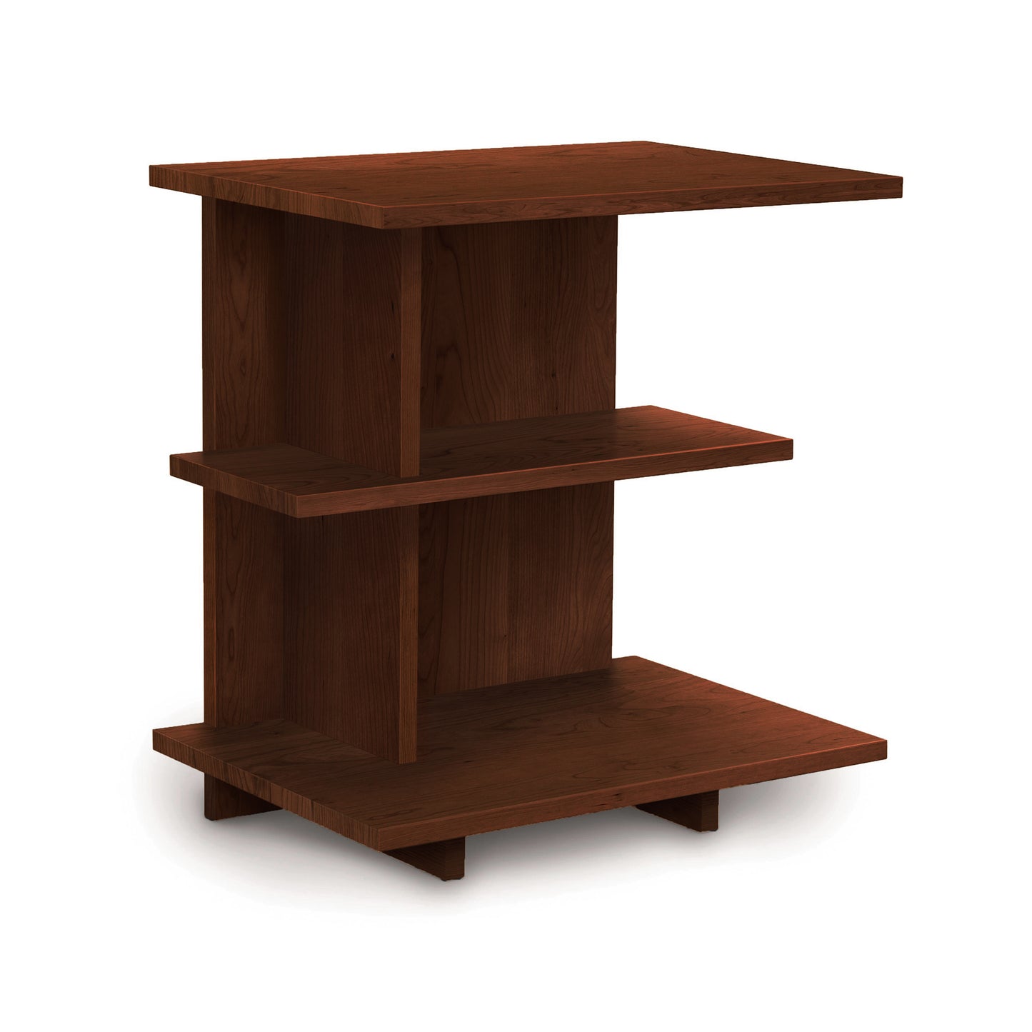 The Mansfield Open Shelf Nightstand from Copeland Furniture is a wooden side table with a modern design, featuring three rectangular shelves of different sizes arranged at varying heights and a dark brown finish. It boasts a flat top, middle shelf, and a base slightly elevated from the ground.