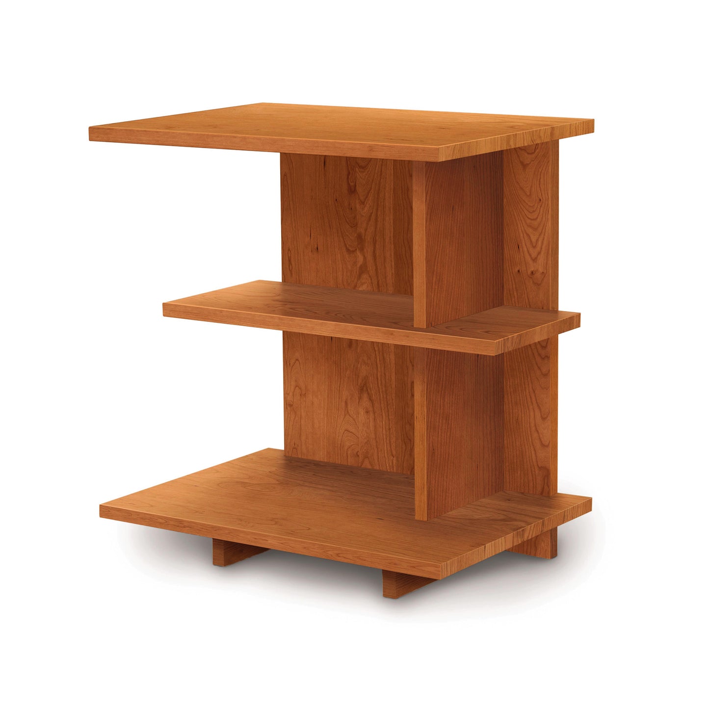 The Mansfield Open Shelf Nightstand by Copeland Furniture is a wooden side table with a modern design, featuring three rectangular shelves positioned at varying heights for a staggered look. Crafted from light brown wood, it stands on four small rectangular legs. Its cherry bedroom furniture aesthetic complements a white background perfectly.