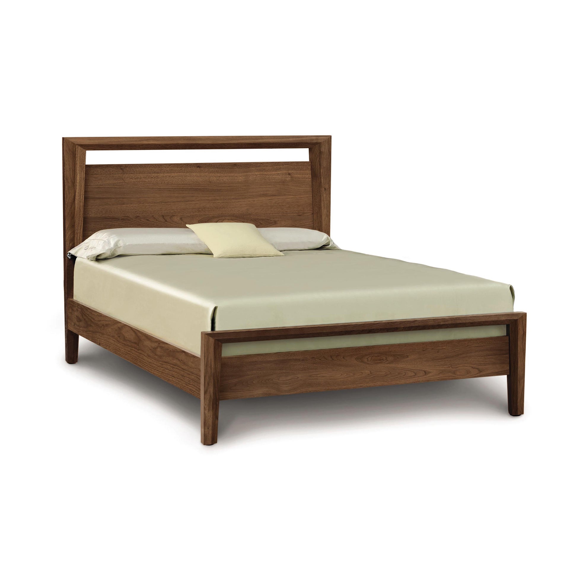 A solid natural Mansfield Walnut Platform Bed in the Arts & Crafts style, with a headboard, supporting a mattress with neatly arranged bedding, isolated against a white background. (Brand Name: Copeland Furniture)