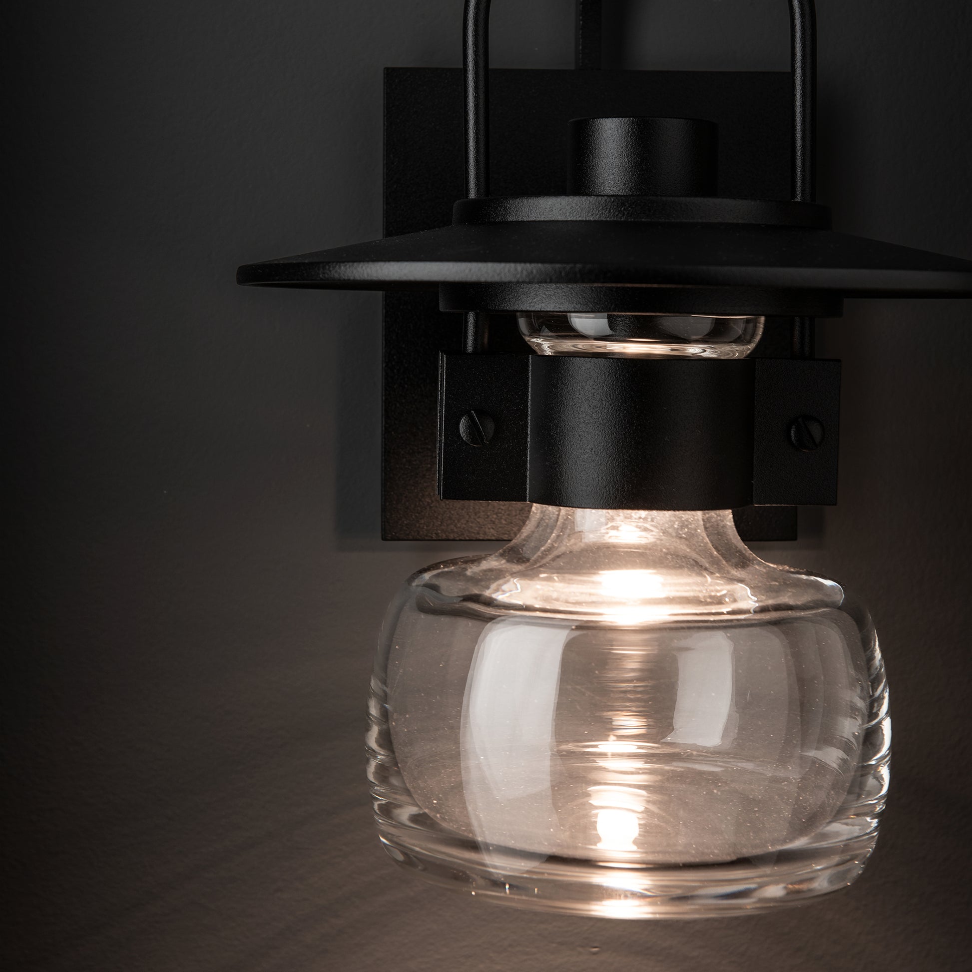 Mason Outdoor Sconce by Hubbardton Forge showcases American craftsmanship with a hand-blown glass shade and black metal design.