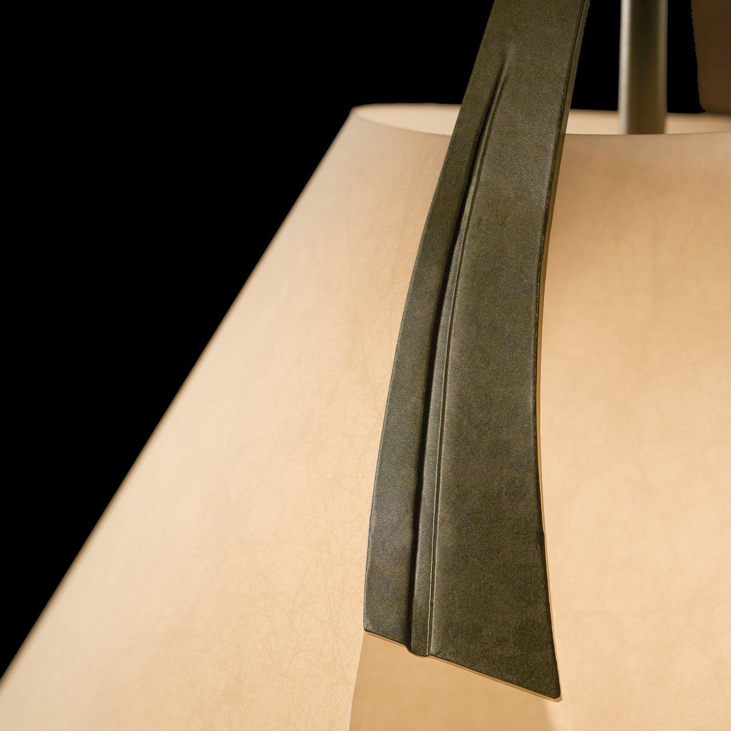 A close up of a Hubbardton Forge Mobius Small Pendant with a paper shade.