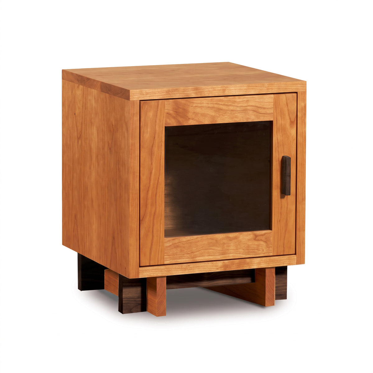 Modern American single-door nightstand by Vermont Furniture Designs with glass door, black handle, square silhouette, and sleek wooden base.
