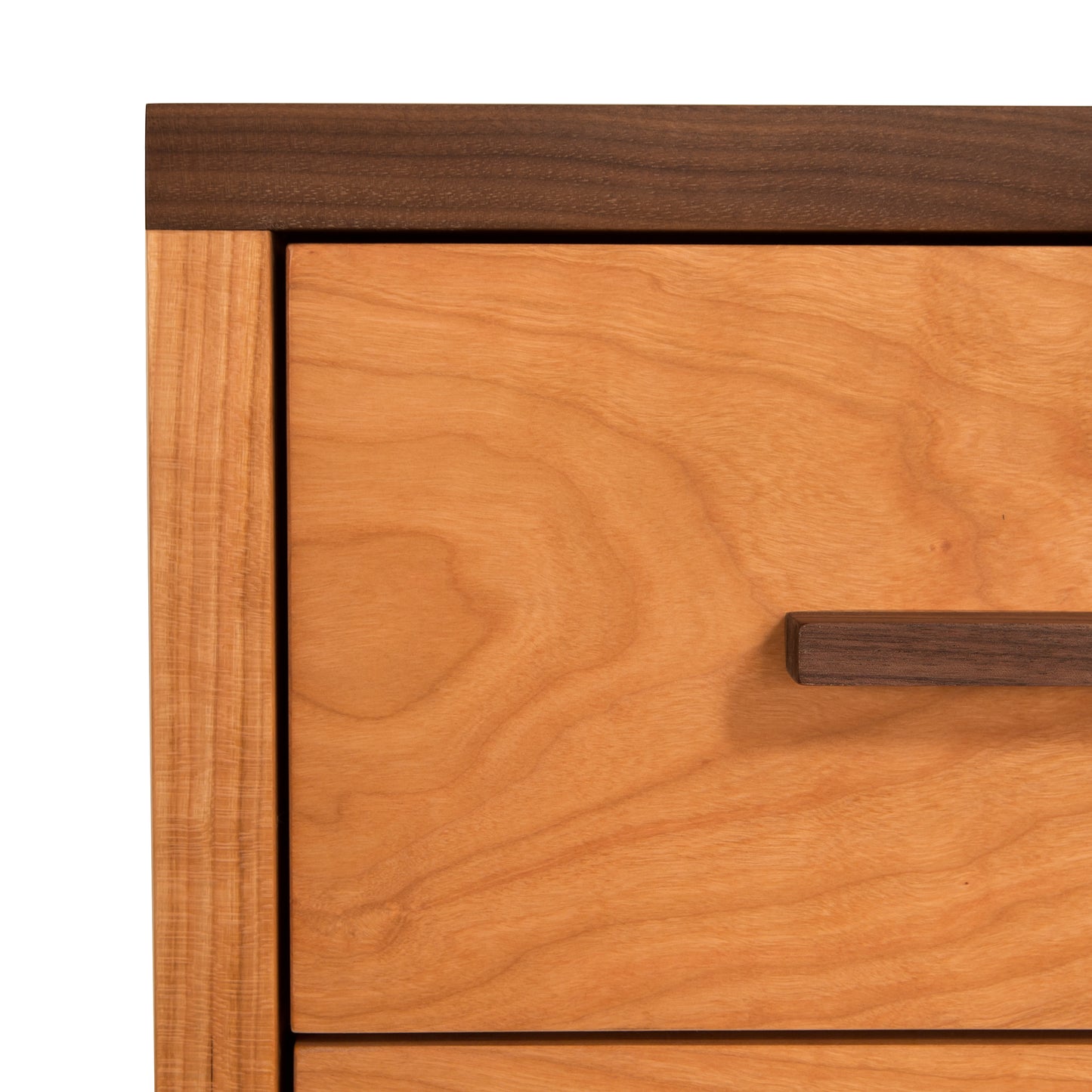 A close up of a Modern American 3-Drawer Nightstand from Vermont Furniture Designs with a contemporary wooden handle.