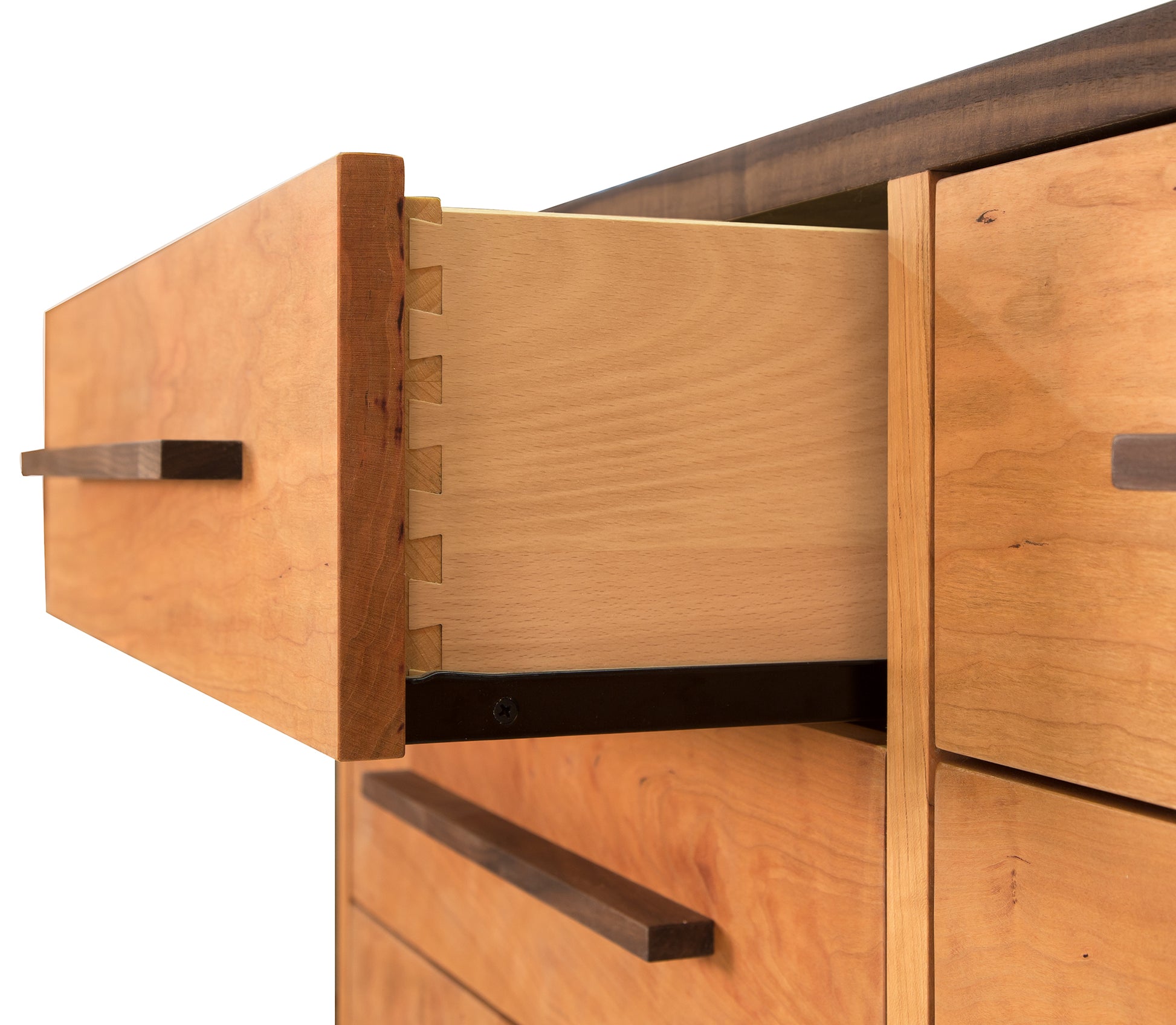 Close-up view of an open drawer in a Vermont Furniture Designs Modern American 8-Drawer Dresser #1, showcasing precise dovetail joints and smooth finish. The surrounding drawers are closed, featuring sleek, rectangular handles.
