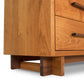 Close-up of a Vermont Furniture Designs Modern American 8-Drawer Dresser #1, showcasing natural cherry wood grain and featuring a drawer with a simple handle and sturdy legs.