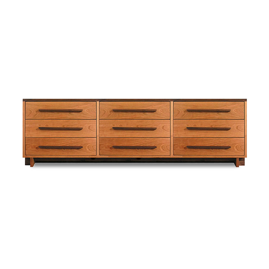 A natural cherry wooden Modern American 9-Drawer Dresser with elongated handles against a plain background. (Brand Name: Vermont Furniture Designs)