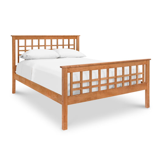 A Modern Craftsman High Footboard Bed from Vermont Furniture Designs, made of solid cherry wood with a lattice headboard and footboard, displaying a white mattress and pillows, set against a white background.