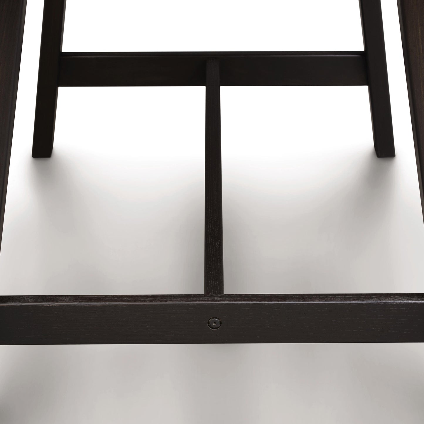 Close-up view of the lower part of a Copeland Furniture Modern Farmhouse Counter Height Farm Table with two legs and a cross beam, featuring a single visible screw, on a white background.