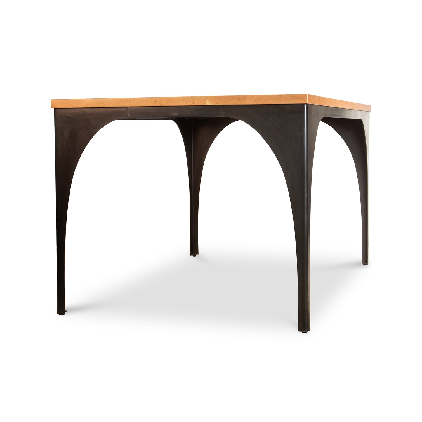 Modern Industrial Arched Table by Vermont Woods Studios showcasing a rectangular wood top with black metal arched legs, American-made craftsmanship.