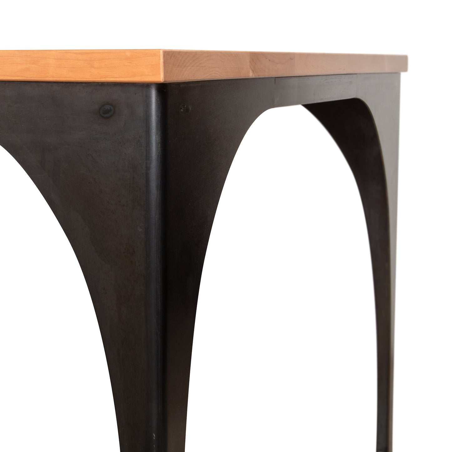 Close-up of the Modern Industrial Arched Table by Vermont Woods Studios, highlighting its American-made light wood top and black metal frame.