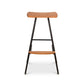 Modern Industrial Stool with a curved wooden seat, black metal legs, and integrated footrest, shown from the front.