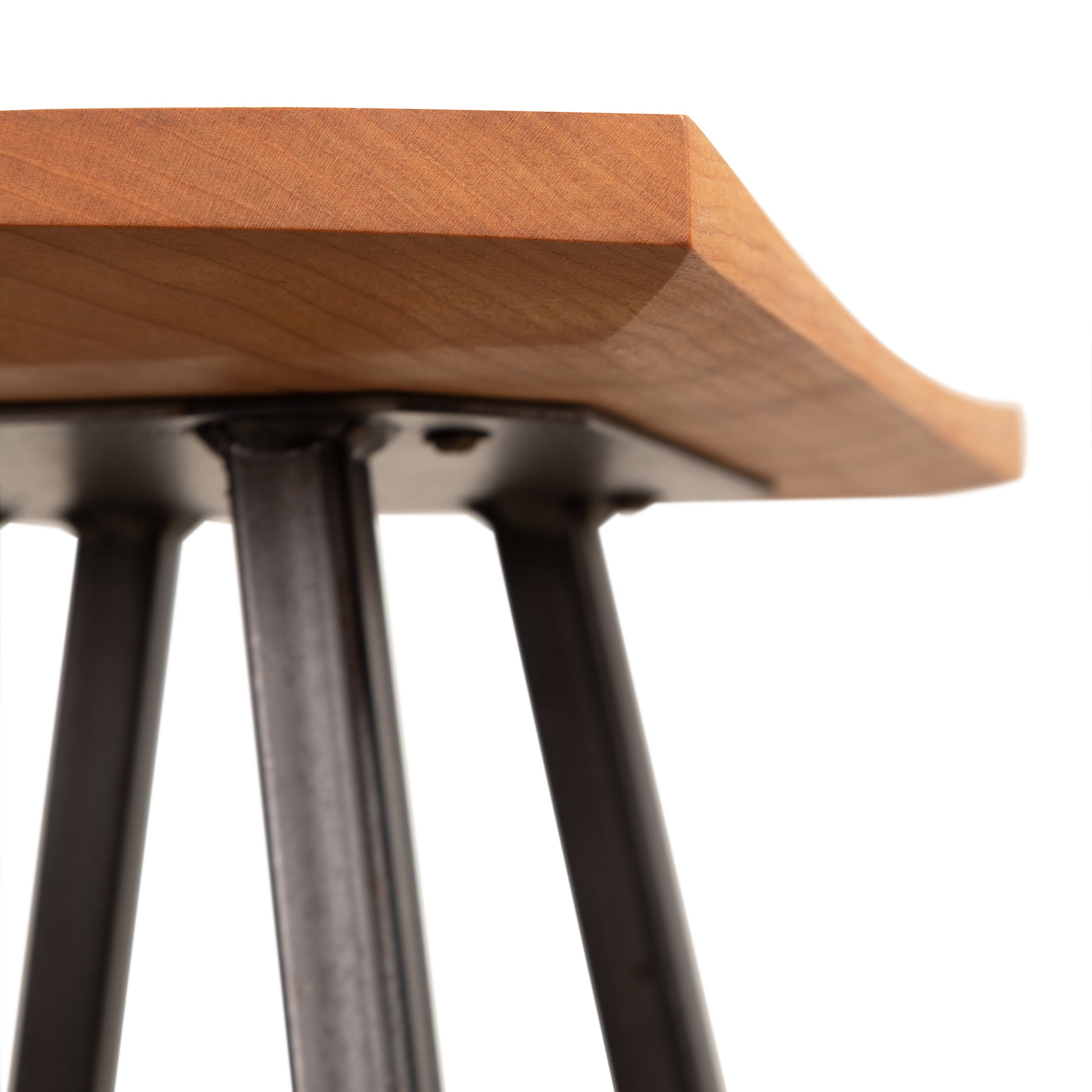 Modern Industrial Stool by Vermont Woods Studios featuring a curved wooden seat and sturdy black metal legs, highlighting its contemporary design and craftsmanship.