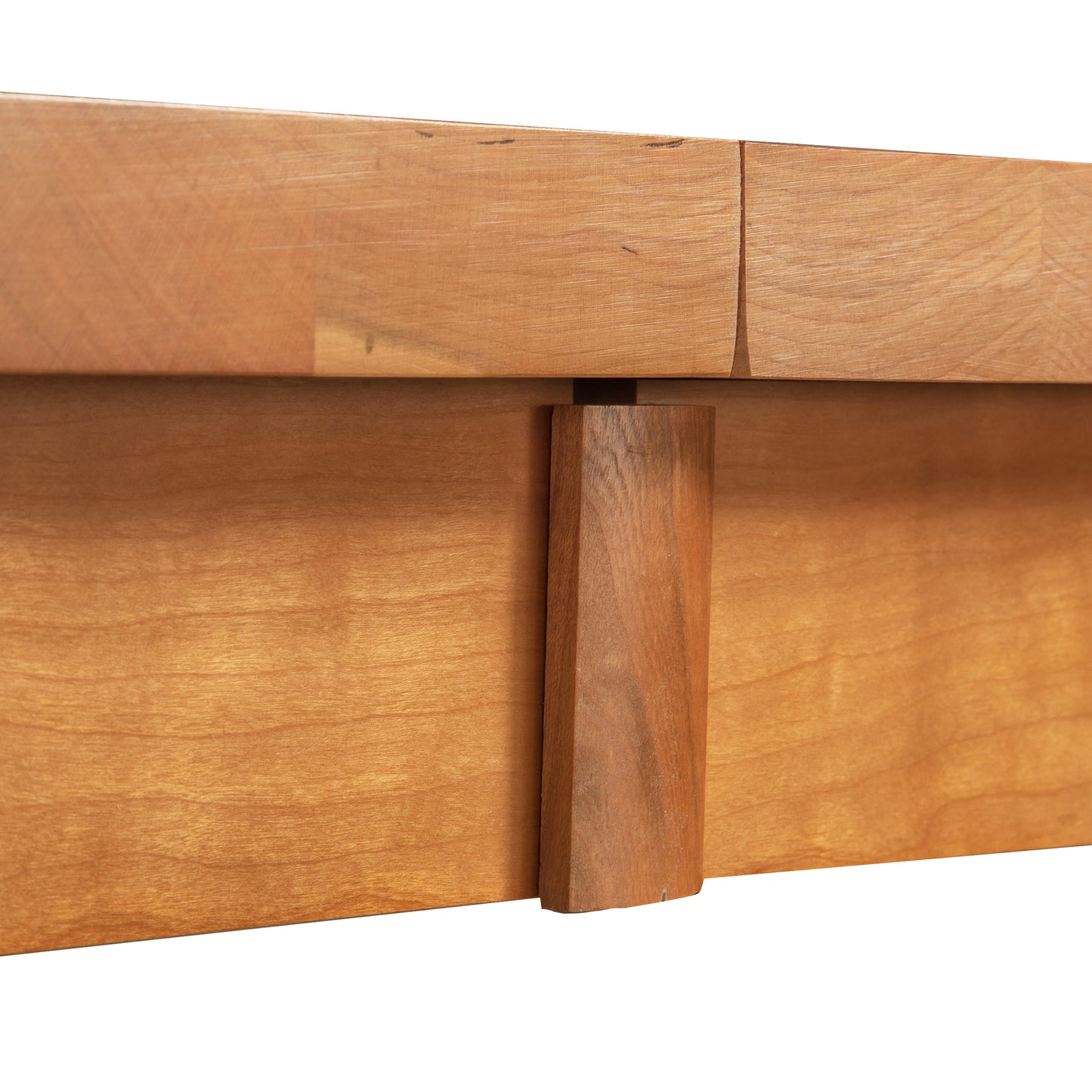 Close-up of dovetail joint on Modern Mission Parsons Extension Table by Lyndon Furniture. Sustainably harvested wood in light to medium brown finish with visible grain patterns. High quality craftsmanship in American made furniture, showcasing solid wood and mission style design.