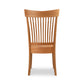 A wooden dining chair with a slatted back.