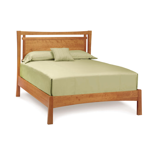 A wooden bed frame with a high rectangular headboard, fitted with light green bedding including a flat sheet, fitted sheet, two pillows, and a small cushion, isolated on a white background. Nearby stands the Copeland Furniture Monterey Platform Bed - Queen - Ready to Ship, offering ample bedroom storage.