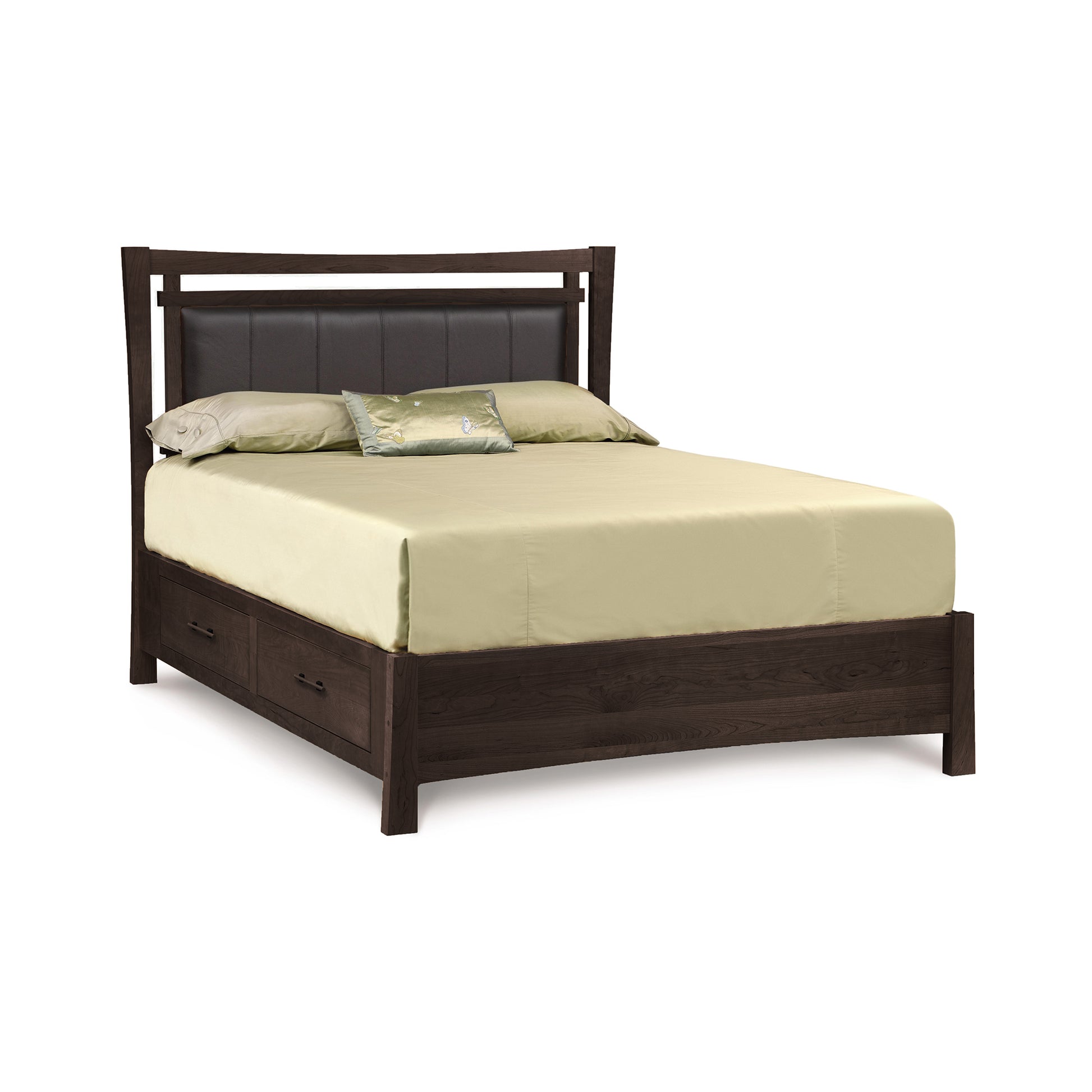 A modern Monterey Storage Bed with Upholstered Headboard by Copeland Furniture, featuring a leather-upholstered headboard and equipped with under-bed storage drawers on one side, made up with a light-colored bedsheet.