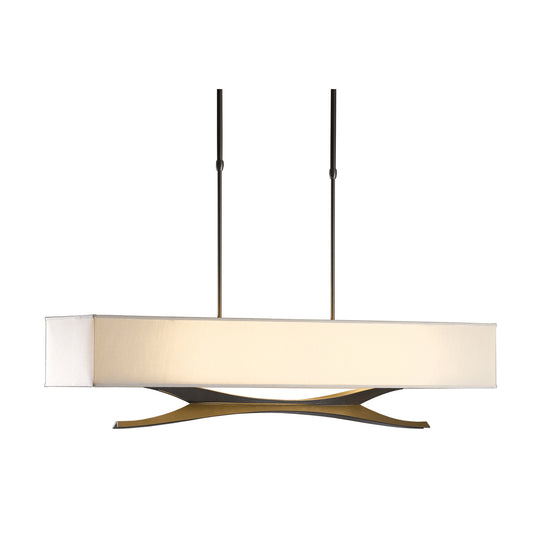 A Moreau Pendant by Hubbardton Forge, a transitional rectangular chandelier with a white shade and a distinctive golden base featuring crisscross design elements, suspended from the ceiling by two thin black cords.