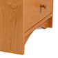 A close up of a wooden nightstand with a drawer.