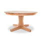 A Lyndon Furniture New Traditions Round Pedestal Table with four legs and a natural finish on a white background.