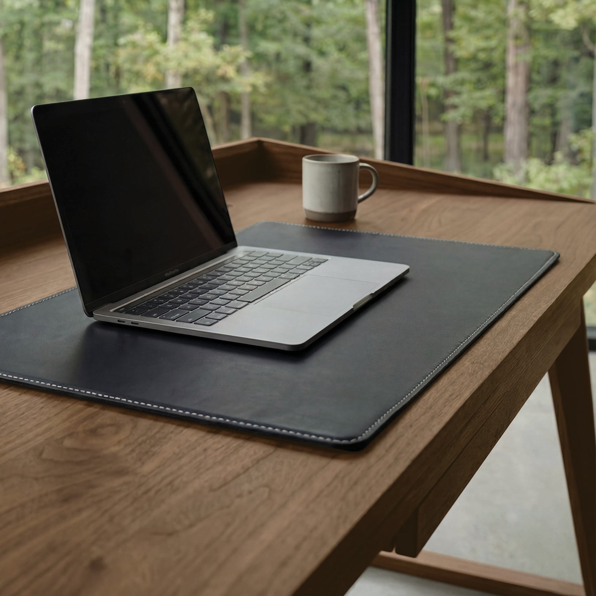 Odin Desk by Copeland Furniture displayed with a laptop and mug, showcasing its solid wood construction and modern design.