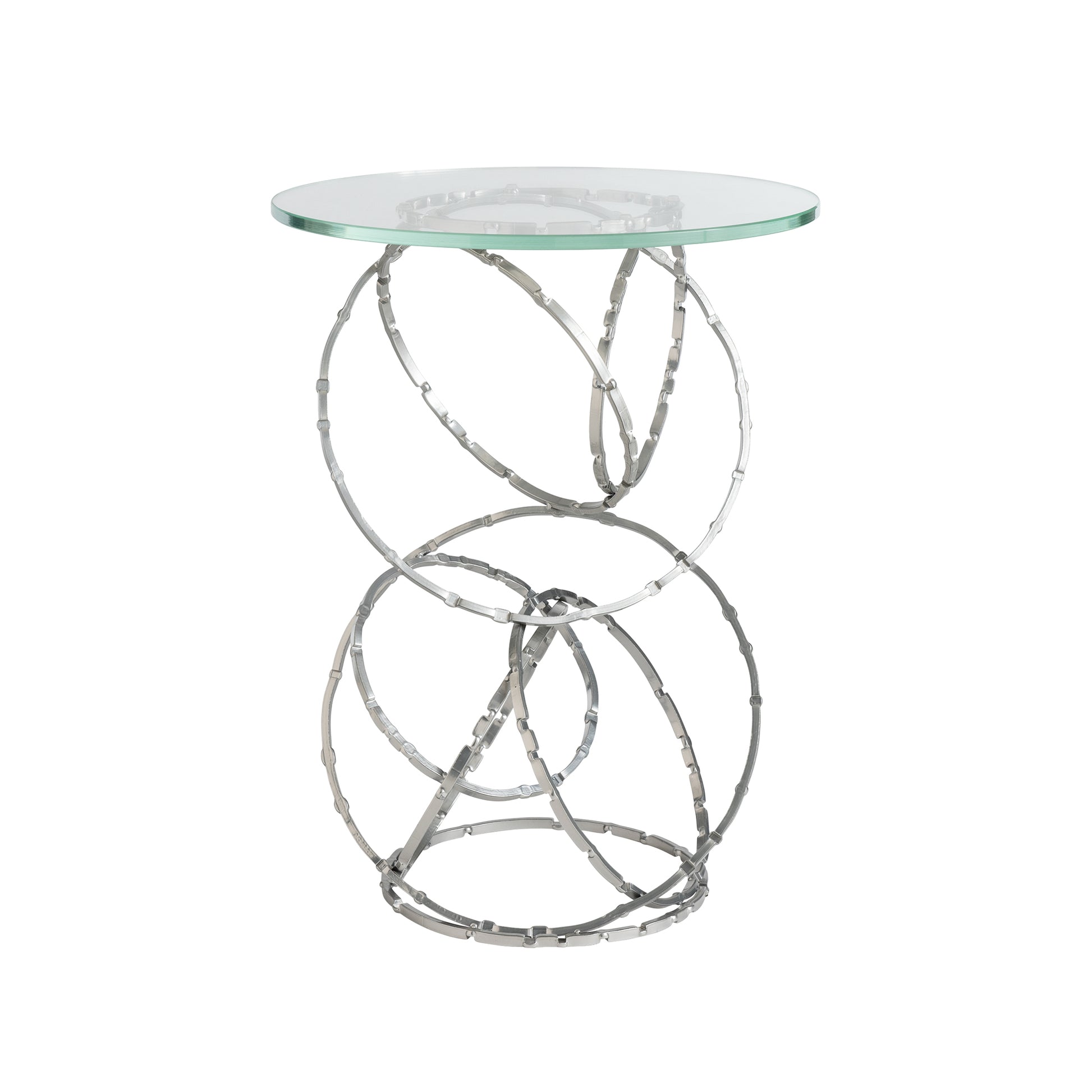 The Olympus Glass Top Accent Table by Hubbardton Forge features a clear, round glass surface supported by a polished metal base of interconnected circular loops, creating a modern and artistic design perfect for contemporary homes.