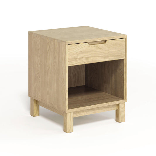 The Copeland Furniture Oslo 1-Drawer Enclosed Shelf Nightstand is a small wooden nightstand with a drawer, made from solid oak hardwood and featuring a beautiful wood finish.