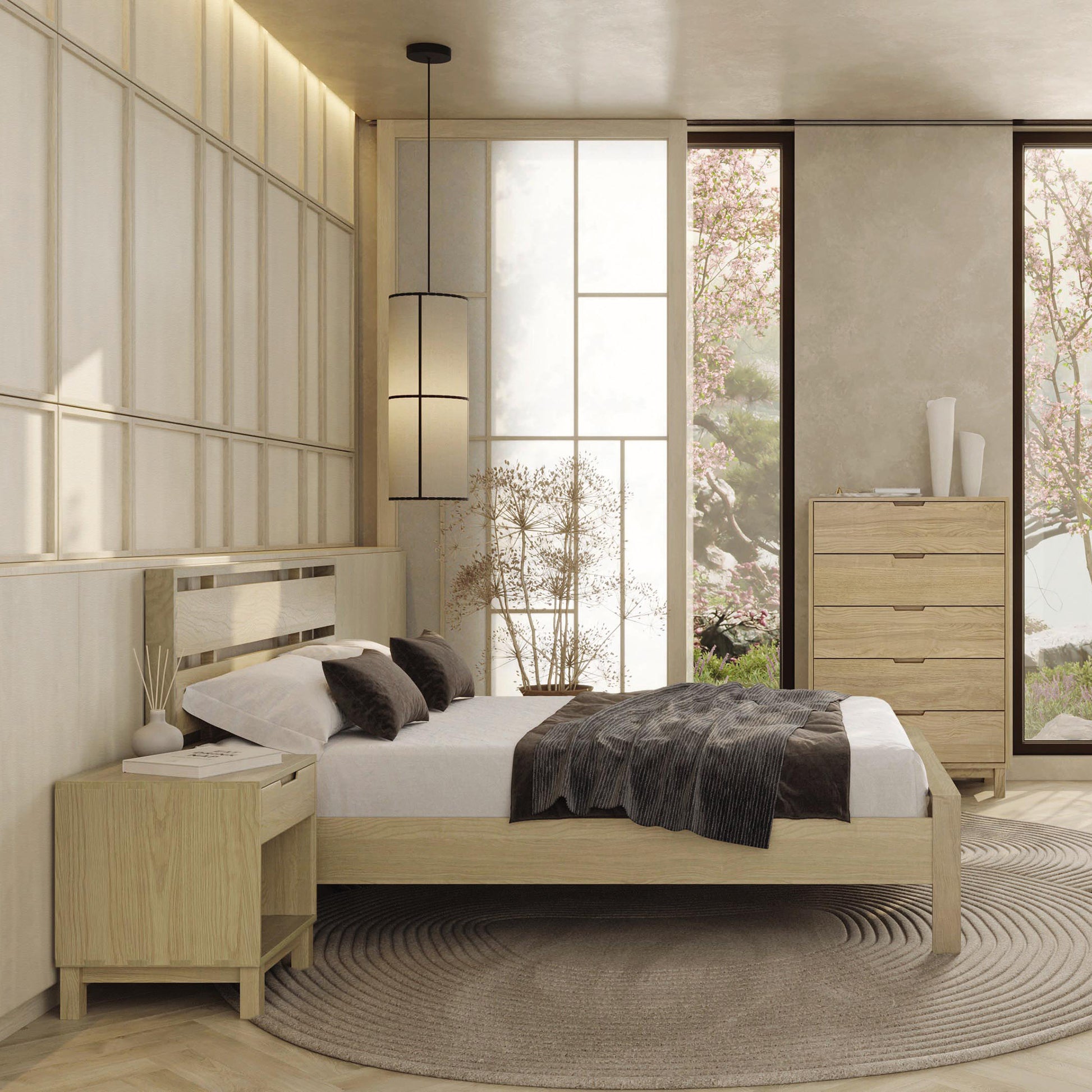 A contemporary bedroom featuring a solid oak hardwood Copeland Furniture Oslo Platform Bed with a white mattress, a bedside table, a dresser, and a circular rug on the floor. Natural light floods in from a large window with